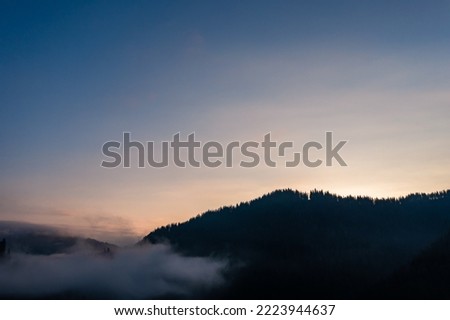 Panoramic view from above of mountain peaks in thick clouds, peaks of the Carpathian mountains.