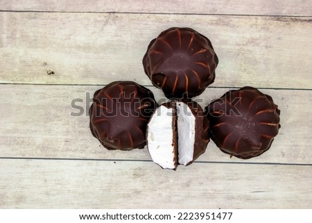 Marshmallows (zefir) in chocolate on wooden background