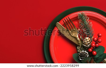 Christmas dinner concept. Vintage old cutlery and christmas ornament with space for text over a red background. Christmas concept background