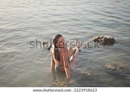 young woman sitting in the water at the sea