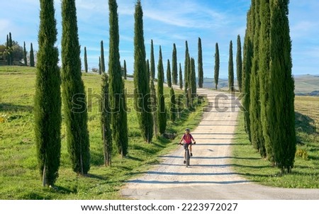 nice senior woman riding her electric mountain bike in the awesome landscape of Tuscany,Italy Royalty-Free Stock Photo #2223972027
