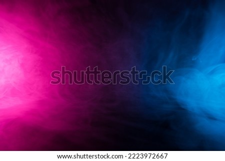 Colorful smoke clouds in neon light swirling on empty scene dark background Royalty-Free Stock Photo #2223972667