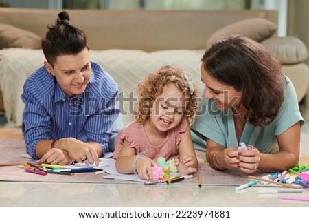Happy mothers and little daughter playing with toys and drawing pictures together at home Royalty-Free Stock Photo #2223974881