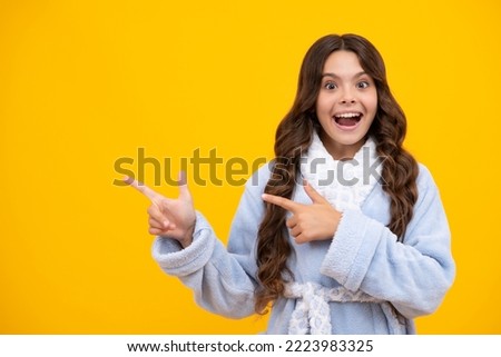 Close-up portrait of her she nice cute attractive cheerful amazed girl pointing aside on copy space isolated on yellow background. Mock up copyspace.