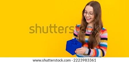 happy teen girl in eyeglasses hold present box for holiday, shopping. Child with birthday gift, horizontal poster. Banner header with copy space.