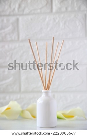 The aroma reed diffuser with the stick perfume are decorated in the room minimal design idea with lily flowers Royalty-Free Stock Photo #2223985669