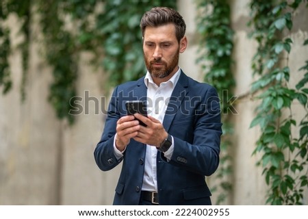 Elegant young businessman with a phone in hands