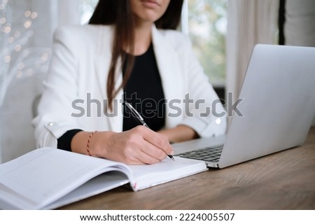 Young brown hair woman working at a desk on a laptop
