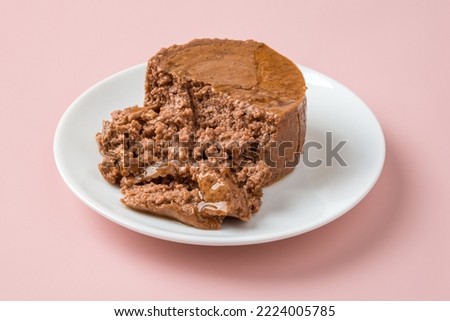 Soft pate for cat on a white plate over pastel pink background. Canned pet food of minced meat on a feeding plate closeup. Feed for carnivore domestic animals. Сat food concept. Front view. Royalty-Free Stock Photo #2224005785