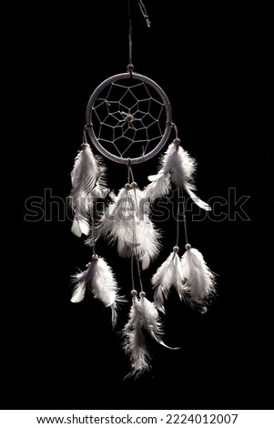 A dream catcher made of white feathers on a black background Royalty-Free Stock Photo #2224012007
