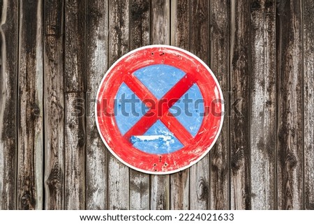 Hand-painted no parking sign (parking prohibition) on a weathered wooden wall