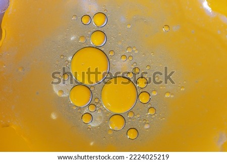 Abstract background with liquid and drops over a blurred backdrop, close up.