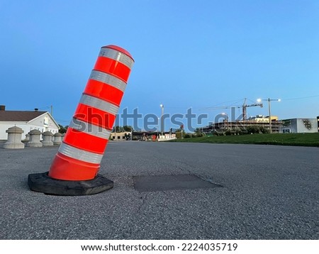 an old orange cone on the street at night