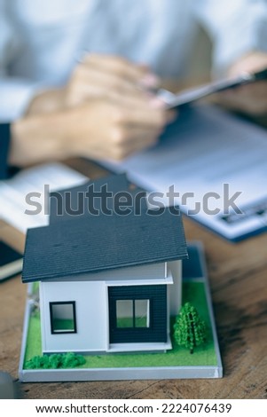 Real estate agents recommend homes and offer insurance interest rate contracts to clients in the home buying idea office.
