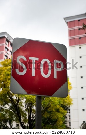 Stop sign with a nice urban residential buildings in a background. A warning traffic sign for everyone's safeness.