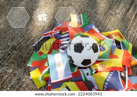 Leather soccer ball on the ground with international team flags of the participating country in the championship tournament. Football equipment to play competitive game. Top view