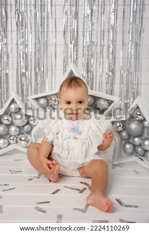 Portrait of little girl, happy child, toddler, baby joyfully sitting and laughing on white studio background. Concept of childhood, motherhood, life, birth.