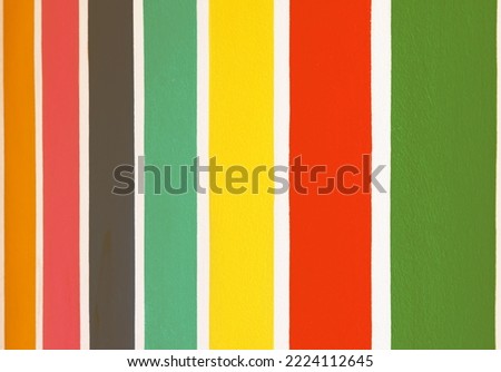 Multicolor vertical striped pattern on cement wall. Colorful painted on cement surface of the wall. Graffiti in the colors of rainbow. Colour full of wall. Color fence, Multi-colored concrete fence.