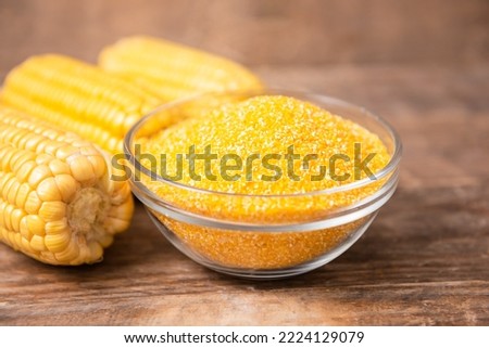 Corn grits polenta in a glass bowl on wooden table
