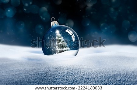 Transparent glass Christmas ball in snow Royalty-Free Stock Photo #2224160033