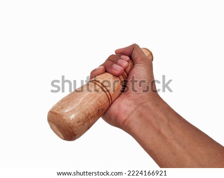 Hand holding a wooden pestle isolated on white background  Royalty-Free Stock Photo #2224166921