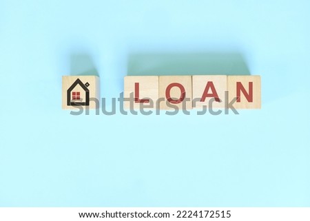 Housing and property loan concept in real estate. Wooden blocks typography on blue background.