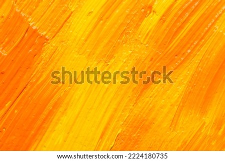 Beautiful strokes of yellow and orange oil paints as background, closeup