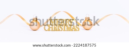 Merry Christmas banner. Shiny Merry Christmas card with golden glitter lettering. Gold baubles and spiral ribbon on a white background.