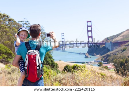 family of two exploring san francisco and golden gate bridge, taking picture of it