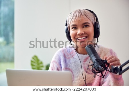 Woman Recording Podcast Or Broadcasting On Radio In Studio At Home With Laptop