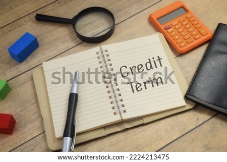 Credit Term wording on a book with calculator pen and magnifying glass. Business and economy concept