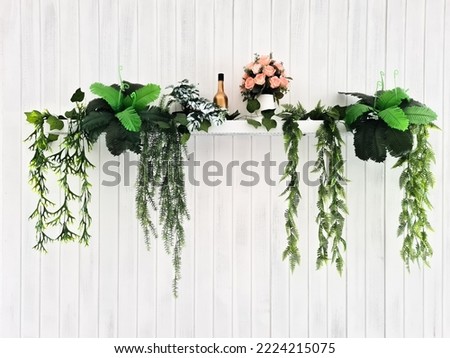 wall decor with hanging wooden pots decorated with artificial flowers on a white wall.  interior decoration concept