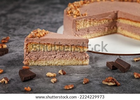 Chocolate cake nut. Homemade, creamy cake with nuts and cream, on a light table