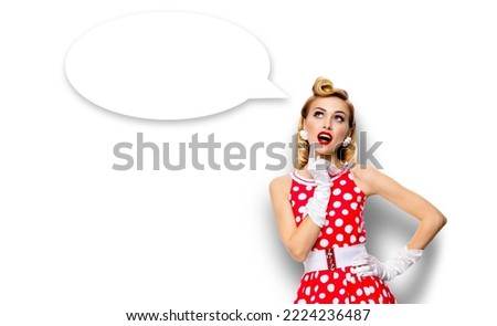Studio portrait image of thinking woman in red pin up dress. Blond pinup thougthfull girl isolated over white background White empty blank speech sign bubble having idea. Mockup, ready for your design