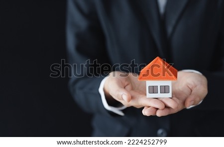 Real estate agent holding house model,  customer signing contract to buy house, insurance or loan real estate.