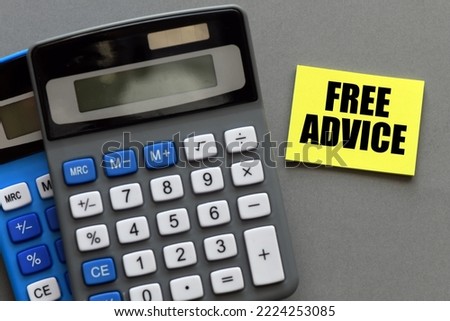 FREE ADVICE words on a small piece of yellow paper and gray background next to calculators.