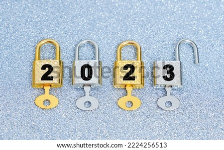Unlocking the new year 2023: row of four labeled padlocks with master keys isolated on a sparkling background. Royalty-Free Stock Photo #2224256513