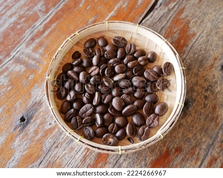 Coffee beans in a bamboo cup placed on a wooden table.