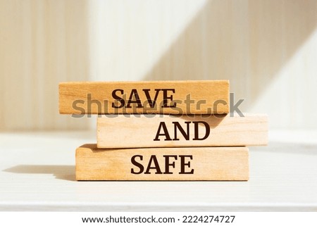Wooden blocks with words 'Save and Safe'.