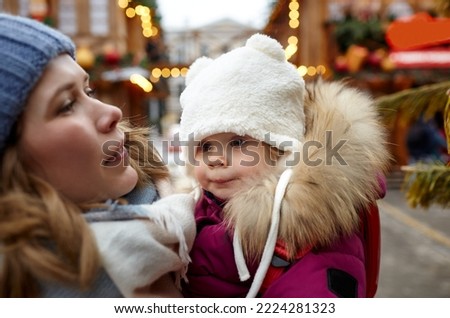 Mother and daughter are walking around the city on Christmas and New Year holidays. Portrait of happy mother and daughter having fun in the street