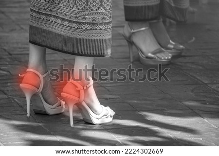The black amd white picture of women wearing high heel shoes and there're red spots to present for the hurt of Plantar fasticis on foot palm or heels. 