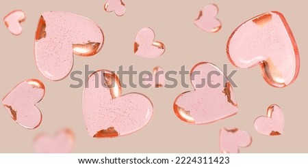 Flying heart shaped pink sweets on beige background. Valentines day greeting card. Banner.