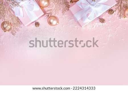 Rose gold Christmas, New Year background with golden christmas tree twigs and balls, holiday gift boxes, decorations, artificial snow, flat lay on pink background copy space