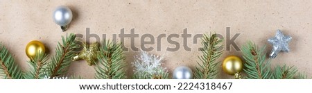 border of fir tree branch with gold decoration on craft paper for christmas card with copy space for text. Happy New Year concept. Holiday background. Christmas mock-up. Top view, flat lay