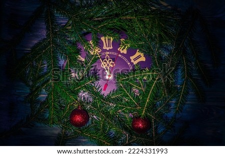 Christmas background with clock and tree branches out of focus.