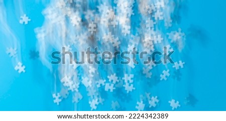 blurred fuzzy black and white jigsaw pieces on blue background
