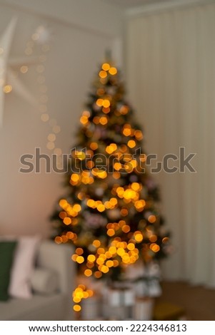 Defocused Christmas tree. Christmas tree silhouette with garland lights on background