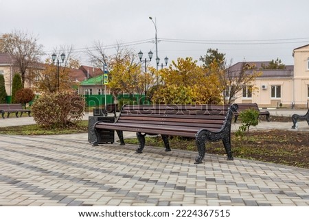 Simple benches on a paved square in an empty autumn park.
