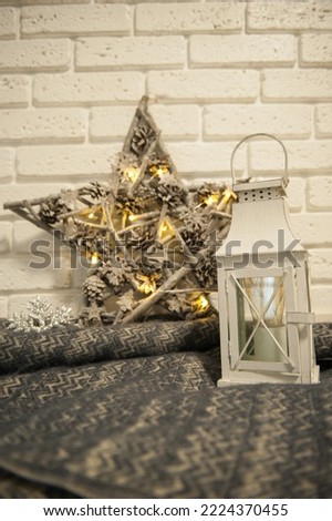 Winter background with a plaid, a lantern and a Christmas star against a white brick wall