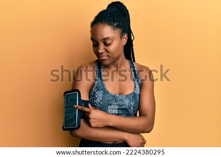 African american woman with braided hair wearing sportswear using arm band skeptic and nervous, frowning upset because of problem. negative person. 